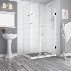 a bathroom with a sink, toilet and shower stall in white tiled walls next to a stand up shower