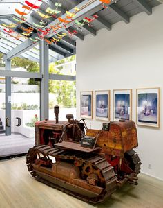 an old bulldozer sits in the middle of a room with pictures on the wall