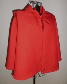 a red cape on a mannequin stand