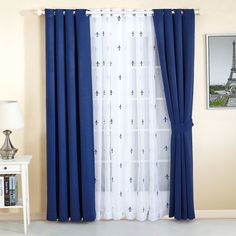 the curtains in this living room are blue and white, with the eiffel tower behind them