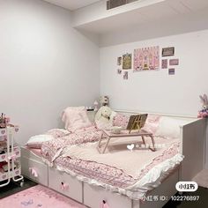 a pink and white bedroom with lots of stuff on the bed, including a teddy bear