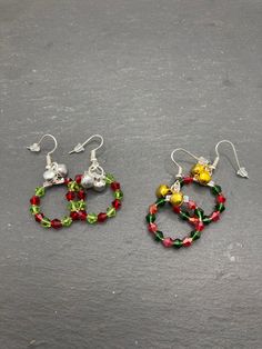 A pair of festive Christmas wreath earrings made with red and green bicone glass beads with small silver bells.  Shades of red and green beads may vary from pictures shown based on availability All items are packaged using recyclable materials where possible to ensure they are protected in transit.  Multiple items will be packed together unless you require separate packaging, for instance, if you are gifting the items.  Please leave me a message if you require this as an option. Dispatched with Christmas Wreath Earrings, Wreath Earrings, Beaded Projects, Recyclable Materials, Silver Bells, Green Beads, Glass Earrings, Green Bead, Star Charms