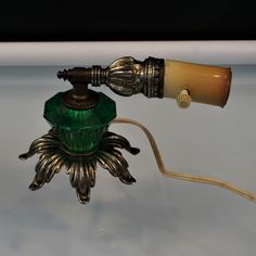 an old fashioned lamp with a green glass shade