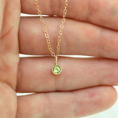 Very classy, simple, and dainty. This handcrafted gold pendant has a natural Peridot stone and comes on your choice of a 16 or an 18 inch gold chain with the artist's tag attached to the clasp. It can also be paired with other pendants! Mix and match to create your own personalized necklace or mother necklace! The pendant is also available without the chain, please make your selection when adding the item to your cart. Gold is 14ky. Stone measures 4mm in diameter. Birthstone for August. Comes wi Yellow Gold Dainty Necklace For May Birthstone, Minimalist May Birthstone Charm Necklace, Dainty Tiny May Birthstone Jewelry, Dainty 14k Gold Charm Necklace For May Birthstone, Minimalist 14k Gold Charm Necklace With May Birthstone, 14k Gold Necklace With May Birthstone, Simple 14k Gold Birthstone Jewelry, Stamped 14k Gold Necklace For May Birthstone, Delicate Yellow Gold May Birthstone Necklace