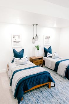 two beds in a room with blue and white bedding