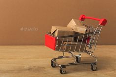 a miniature shopping cart filled with boxes on top of a wooden table