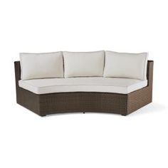 an outdoor sectional sofa with cushions and pillows on the back, in front of a white background