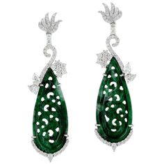 These stunning hand carved Jade earrings are crafted in 18-karat white gold. It is set in 18.5 carats Jade and 1.9 carats of sparkling diamonds. FOLLOW MEGHNA JEWELS storefront to view the latest collection & exclusive pieces. Meghna Jewels is proudly rated as a Top Seller on 1stDibs with 5 star customer reviews. All items manufactured by us are handmade and can be customized or redesigned. Composition Size-57X16 MM Total Weight-14.746 Gold Weight(Gms)-10.666 Diamond Wt(Cts)-1.9 Jade Wt(Cts)-18. Luxury Platinum Diamond Earrings Hallmarked, Luxury Carved Earrings For Formal Occasions, Luxury Carved Earrings, Elegant Carved Earrings For Formal Occasions, Luxury Earrings With Intricate Design, Elegant Carved Drop Earrings, Luxury Pierced Diamond Earrings For Anniversary, Carved Diamond Fine Jewelry, Fine Carved Diamond Jewelry