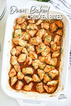 chicken bites in a white casserole dish with sauce and parsley on the side