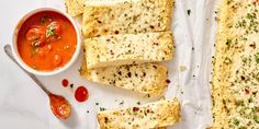 slices of bread with tomato sauce and parmesan bread on the side next to it