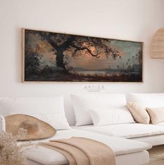 a white couch sitting under a painting on the wall