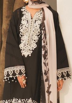 A beguiling midnight black overlaid with expertly rendered embroidery inspired by modern Moroccan motifs. Paired with a digitally printed silk dupatta with a dramatic chrysanthemum flower, this dynamic and artistic design will undoubtedly make you reign supreme in your tribe. Front Embroidered Kali On Lawn. Dori Embroidered Neck On Organza. Embroidered Patti On Organza For Sleeves. Printed Border On lawn. Dyed Back On Lawn. Dyed Sleeves On Lawn. Digital Printed Silk Dupatta. Dyed Cotton Pants. C Party Tunic Dress With Dupatta, Tunic Party Dress With Dupatta, Elegant Cotton Dresses For Eid, Long Sleeve Cotton Dress With Dabka Work, Black Long Sleeve Georgette Dress, Black Long Sleeve Dress With Lace Work, Traditional Long Sleeve Dress With Lace Work, Long Sleeve Summer Dress With Dabka Work, Summer Long Sleeve Dress With Dabka Work