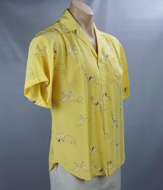 Exquisite bright yellow button front silk blouse or shirt. Patterned with little red, white and blue sailors. Short sleeves with a single breast pocket.Buttons are on the right side which usually indicates men's wear. However, it is tagged a size 10 which usually indicates women's wear. Excellent condition. It was found in the dry cleaning bag still with the cardboard under the collar.Labeled I K E Behar, Made in the U.S.A. Ike Behar is an American clothing brand launched in New York in the 1960 American Clothing Brands, Tropical Print Top, Silk Shirt Blouses, Bow Tie Blouse, I'm Broke, Yellow Silk, Orange Plaid, American Clothing, Bowling Shirts