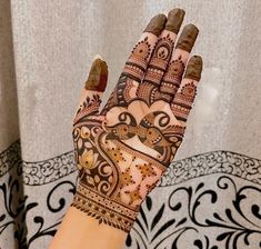 a woman's hand with henna tattoos on it