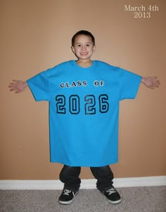 a young boy wearing a blue class of 2012 t - shirt standing in front of a wall