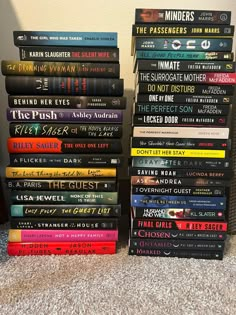 a pile of books sitting on top of a carpeted floor