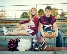 a man and woman sitting on bleachers holding footballs