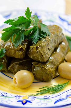 some food is on a blue and white plate with green garnish, as well as chickpeas