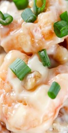 a close up view of some food with cheese and green onions on top, in a white bowl