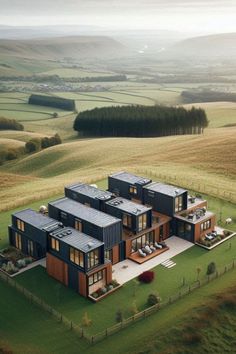 an aerial view of a house in the middle of a field with rolling hills and fields behind it