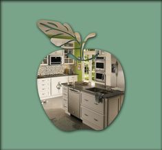 an apple shaped kitchen with stainless steel appliances and green wall paper in the center, surrounded by white cabinets