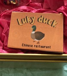 a box filled with lots of pink tissue paper and a duck on top of it