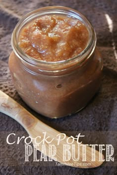 a glass jar filled with food sitting on top of a table next to a wooden spoon