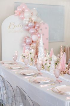 the table is set with pink and white decorations