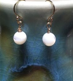 Mother of Pearl Shell Earrings, 14K Gold Filled Petite Creamy White Earrings, Minimalist Natural Beach Earrings, Dangle 1 Bead Made to Order Made to Order: Our mother of pearl earrings will be made to order for you.  If you wish, we will send you photos of your earrings to approve before we ship. The earrings are simple, neutral and minimalist.  For the person who prefers small, minimalist earrings. Mother of pearl (MOP) shimmers as the light hits the surface, so as you move, your earrings will Beach Earrings, Mother Of Pearl Earrings, Shell Bracelet, Earrings Minimalist, Pearl Shell, Shell Earrings, White Earrings, Shell Beads, Earrings Dangle