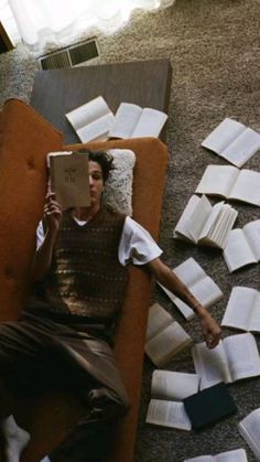 a man laying on the floor reading a book