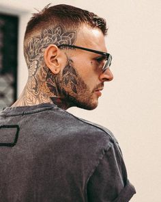 a man with tattoos on his face and neck