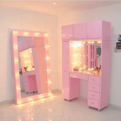 a pink vanity and mirror with lights on it