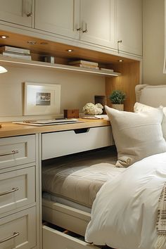 a white bed sitting under a window next to a desk