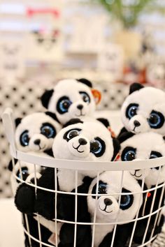 a basket filled with stuffed panda bears sitting on top of a table