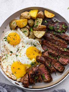 steak, eggs and hash browns on a white plate