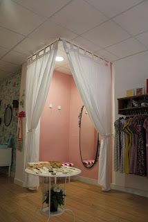 a room with pink walls and white curtains