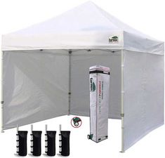 a white tent with four black boots next to it and the sidewalls open