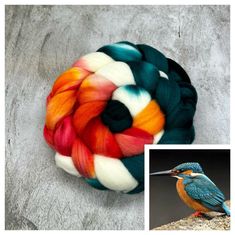 a colorful bird sitting on top of a rock next to a spinning ball with yarn