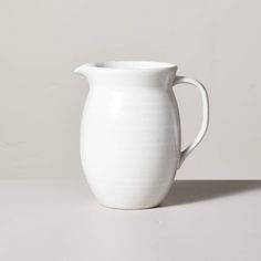 a white pitcher sitting on top of a table