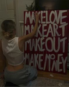 a woman sitting on the floor in front of a sign that says make out money