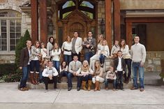 a group of people posing for a photo in front of a building with wooden doors