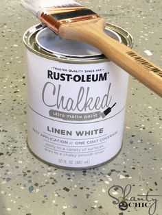 a paint can with a brush on top of it