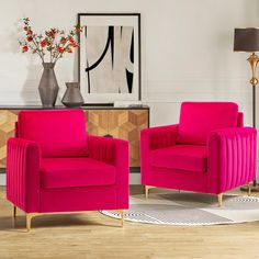 two bright pink chairs sit in front of a painting on the wall next to a rug