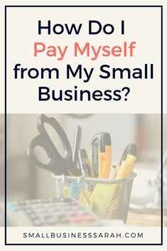 a desk with scissors, pens and pencils on it text reads how do i pay myself from my small business?