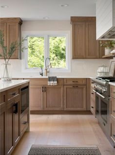 a large kitchen with wooden cabinets and white counter tops, along with an area rug on the floor