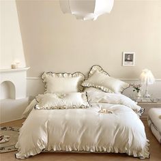 a bed with white sheets and pillows in a room