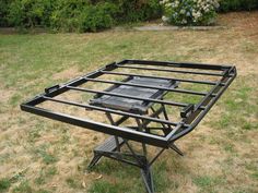 a metal table sitting on top of a grass covered field