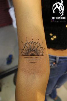 a woman's arm with a sunflower tattoo on the left side of her arm