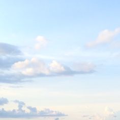 two people are standing on the beach with their surfboards in hand and one person is flying a kite