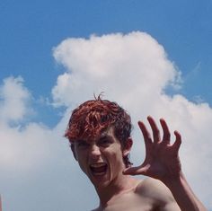 a shirtless man with red hair and no shirt on is holding his hands up in the air